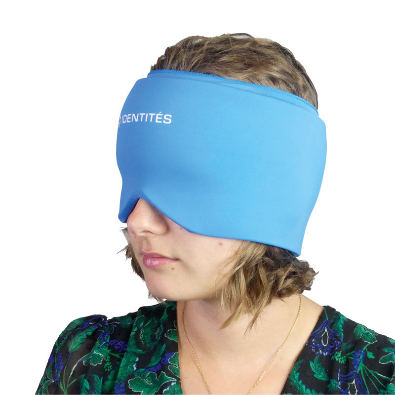 Mulher com a faixa de cabeça de frio GelPro azul colocada sobre a testa e os olhos, de perfil, para alívio de enxaquecas.